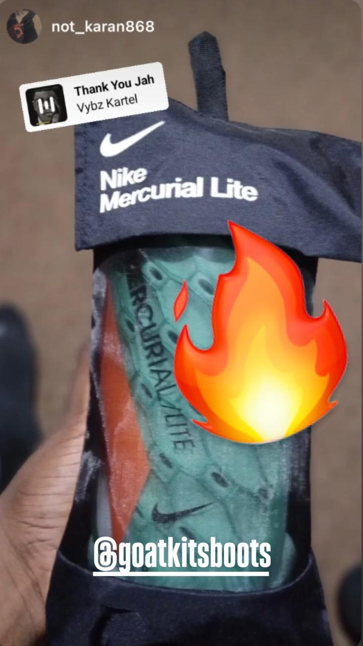 Close-up of Nike Mercurial Lite shin guards in their packaging, featuring vibrant colors and tagged with @goatkitsboots along with a fire emoji, showcasing premium football gear.