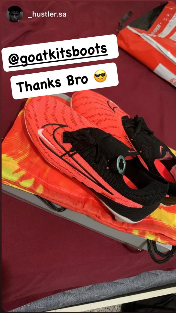 Bright orange and black Nike football boots displayed on their original packaging with a matching drawstring bag, tagged with @goatkitsboots and a 'Thanks Bro' message expressing satisfaction."