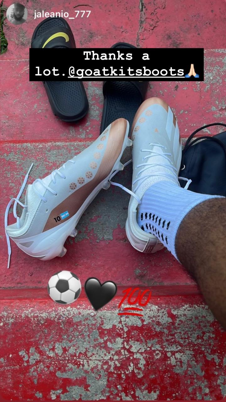 White and gold football boots featuring the number 10 and Argentine flag, worn by a customer on red stairs, tagged with @goatkitsboots and emojis expressing gratitude and excitement.